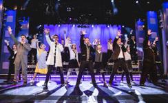 Large ensemble cast celebrating onstage during a Branson live music production