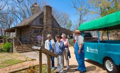 Visitors unloading from a tour tram outside a historic Branson attraction
