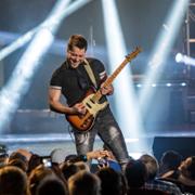 Michael Haygood playing his electric guitar delivering a high-energy solo on a concert stage, spotlights beaming over an engaged audience�signature live music entertainment you can include when you Build your own Branson vacation package.