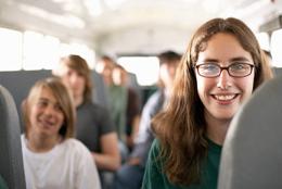 Students smiling and seated on a comfortable tour bus during a group trip - an ideal setup for educational excursions and Branson Student Group Tours.